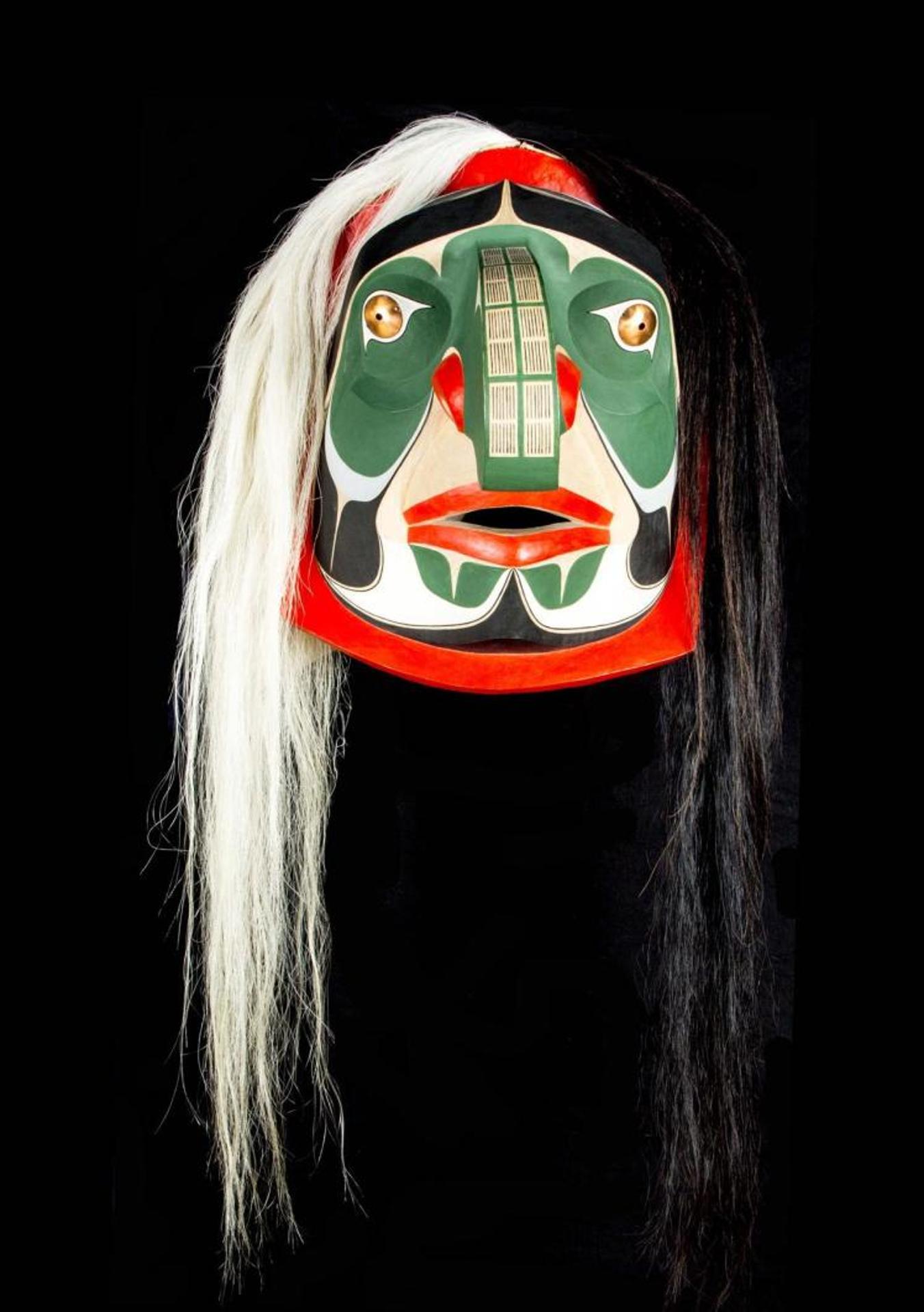 Gene Brabant - a carved and polychromed cedar Fools mask with copper eyes