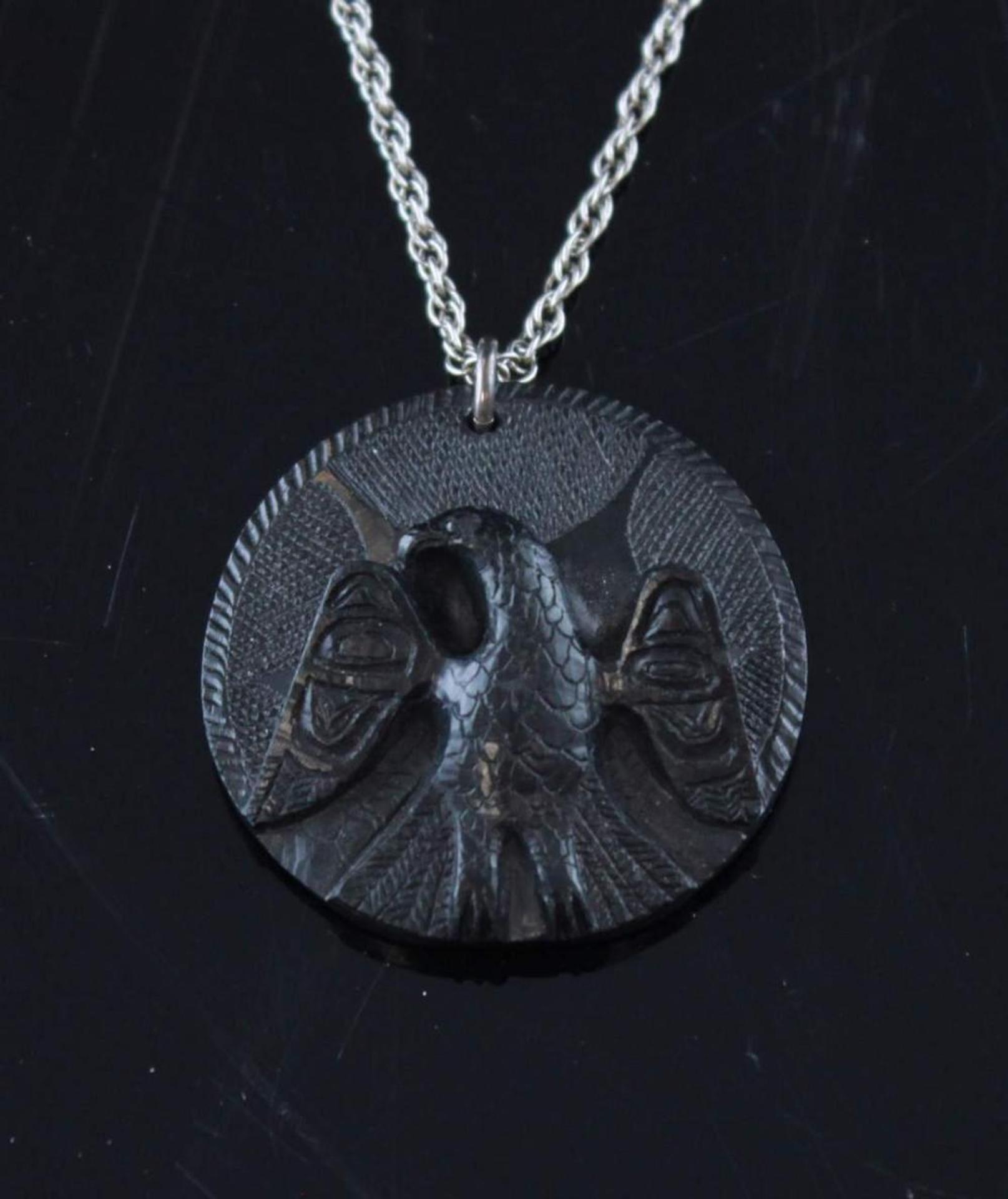 Arthur Moody (1885-1967) - a round carved argillite pendant depicting Eagle