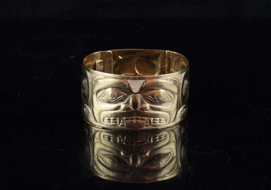 Derek White - an 18kt yellow gold repousse bracelet decorated with Bear design