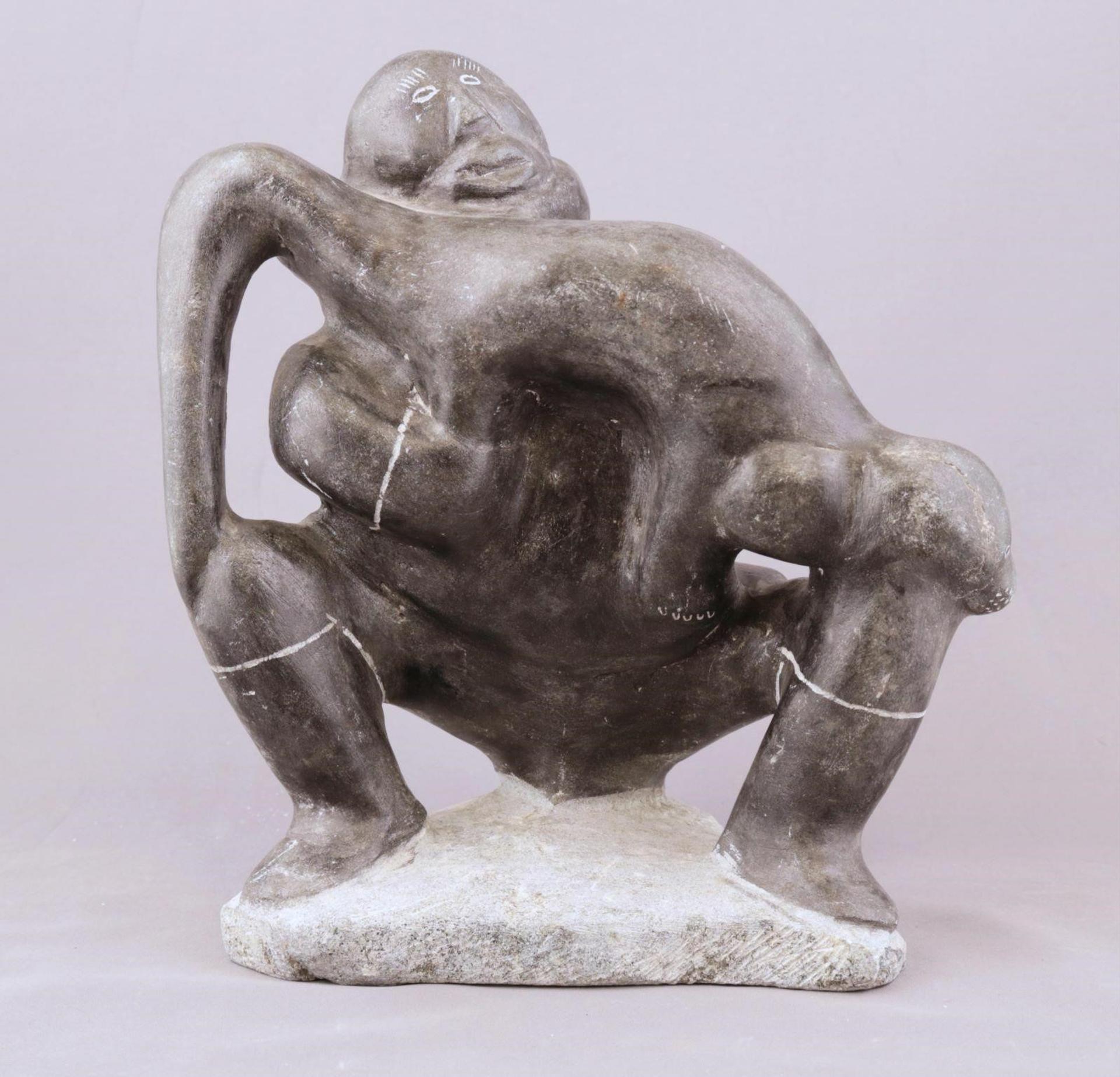 Josephie Angma (1905) - a dark grey stone carving of a Man Holding an Otter