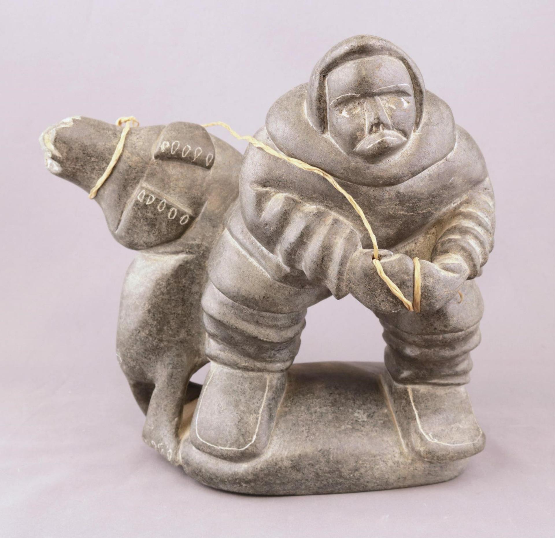 Daniel Quiruagiac - a grey stone carving of a Hunter Hauling in a Seal